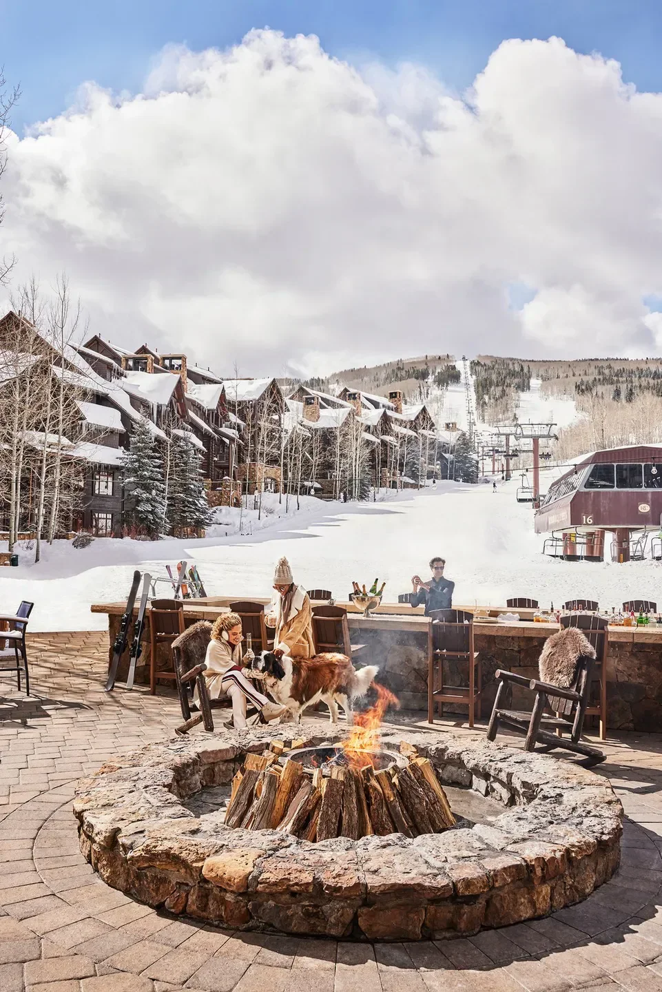 Cozy outdoor fire pit at WYLD restaurant in Vail with skiers and snow-covered slopes