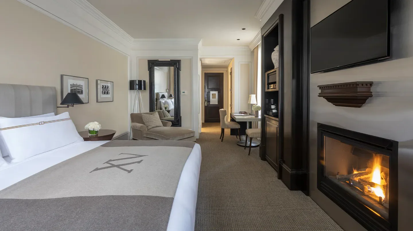 Cozy hotel room at XV Beacon in Boston, featuring fireplace and elegant decor.