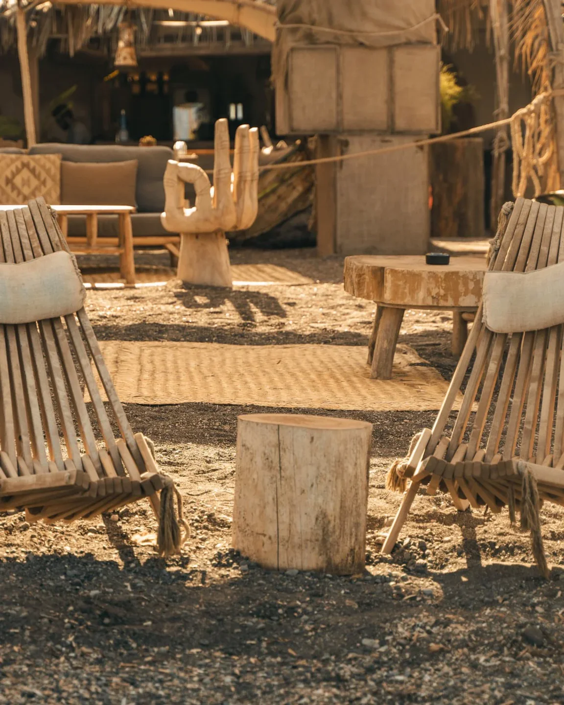 Bohemian outdoor seating area at Yalos, featuring wooden chairs and a hand sculpture, overlooking the city.