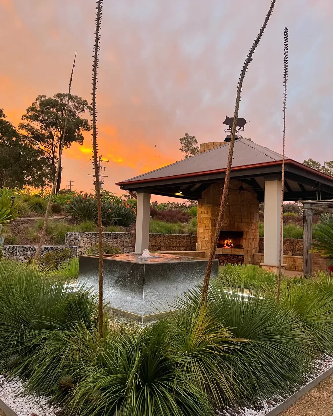 Sunset view at Yellow Billy restaurant in Hunter Valley with water fountain and fireplace.