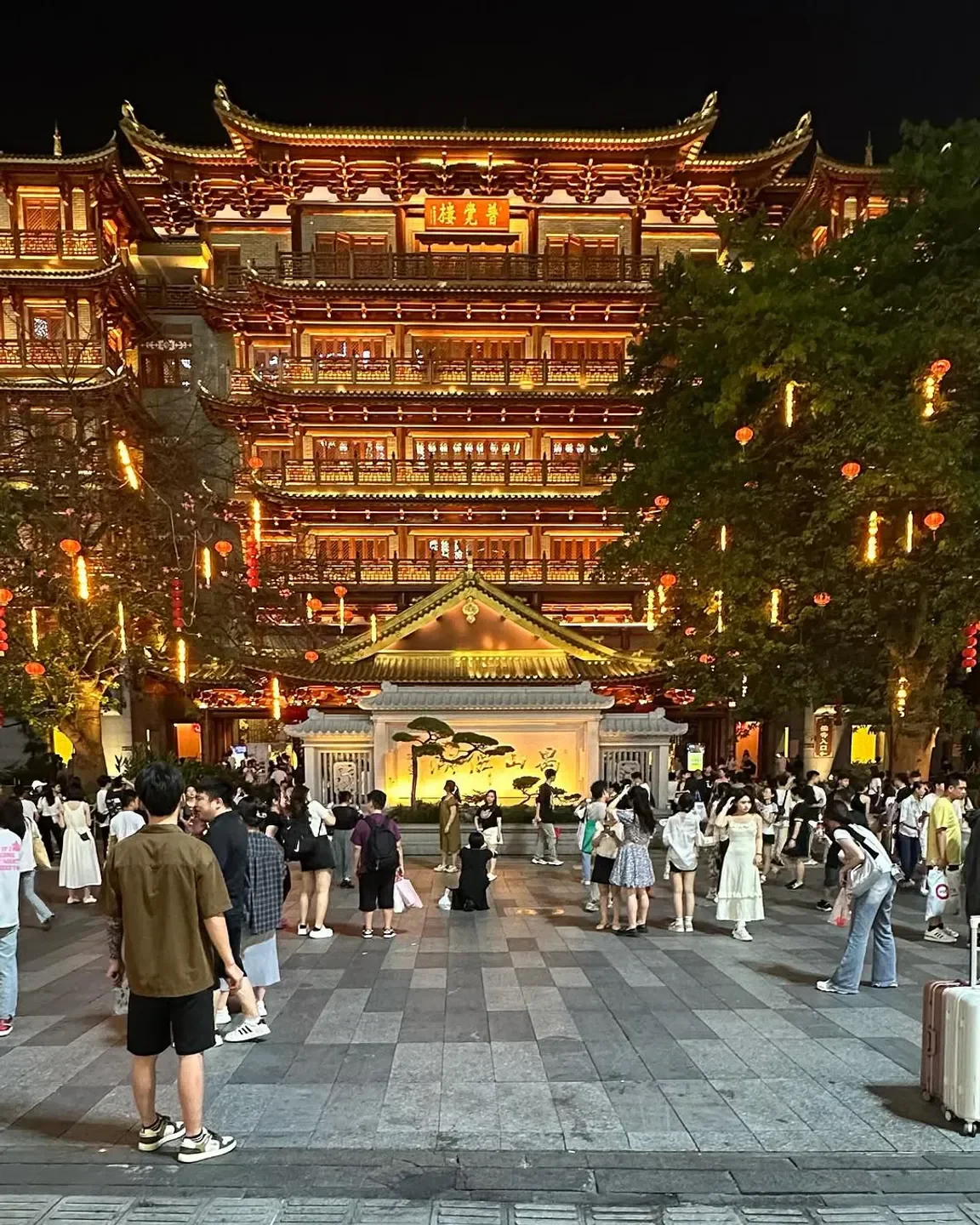 Night view of Yong restaurant in Guangzhou, featuring traditional architecture and crowds.