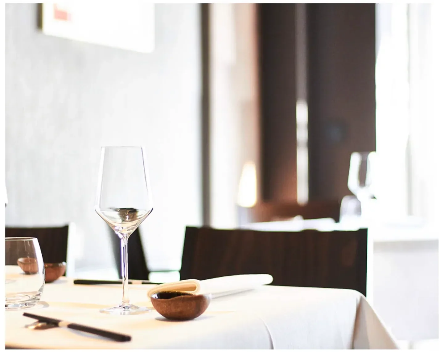 Elegant table setting at Yoshi by Nagaya, a restaurant in Düsseldorf, with wine glasses.