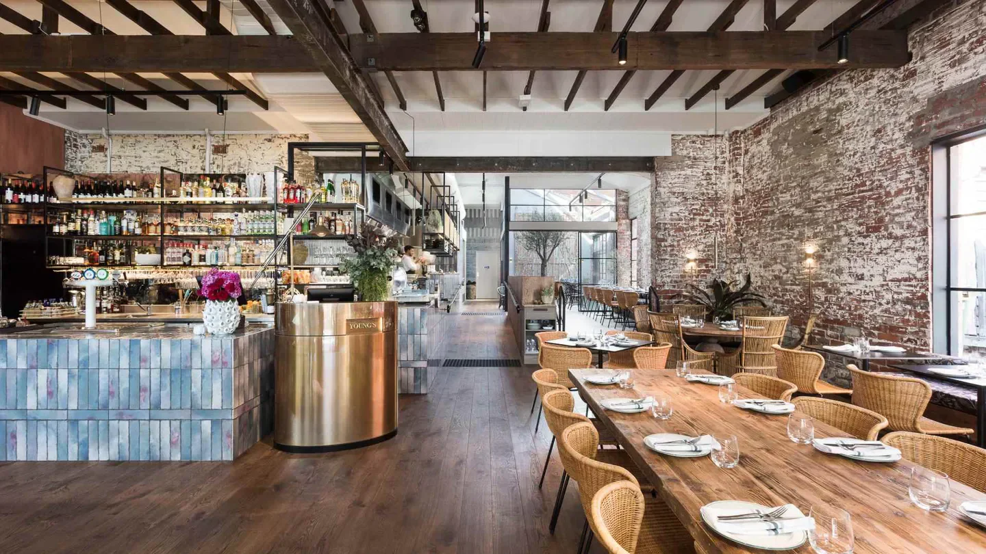 Interior of Young's Wine Rooms in Melbourne, featuring a stylish dining area with exposed brick.