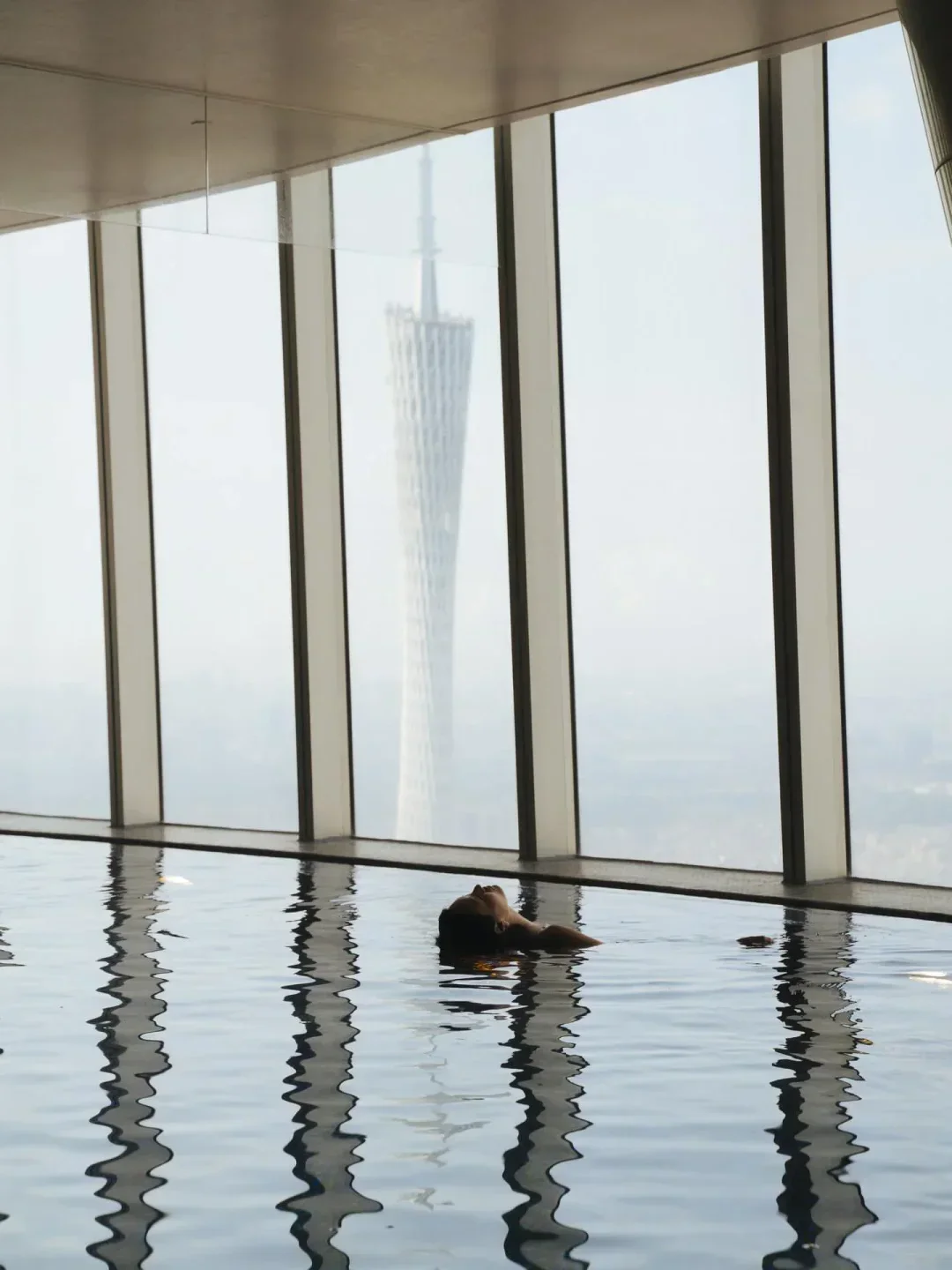Relaxing in the pool at Yu Yue Heen, Guangzhou, with the city skyline in view.