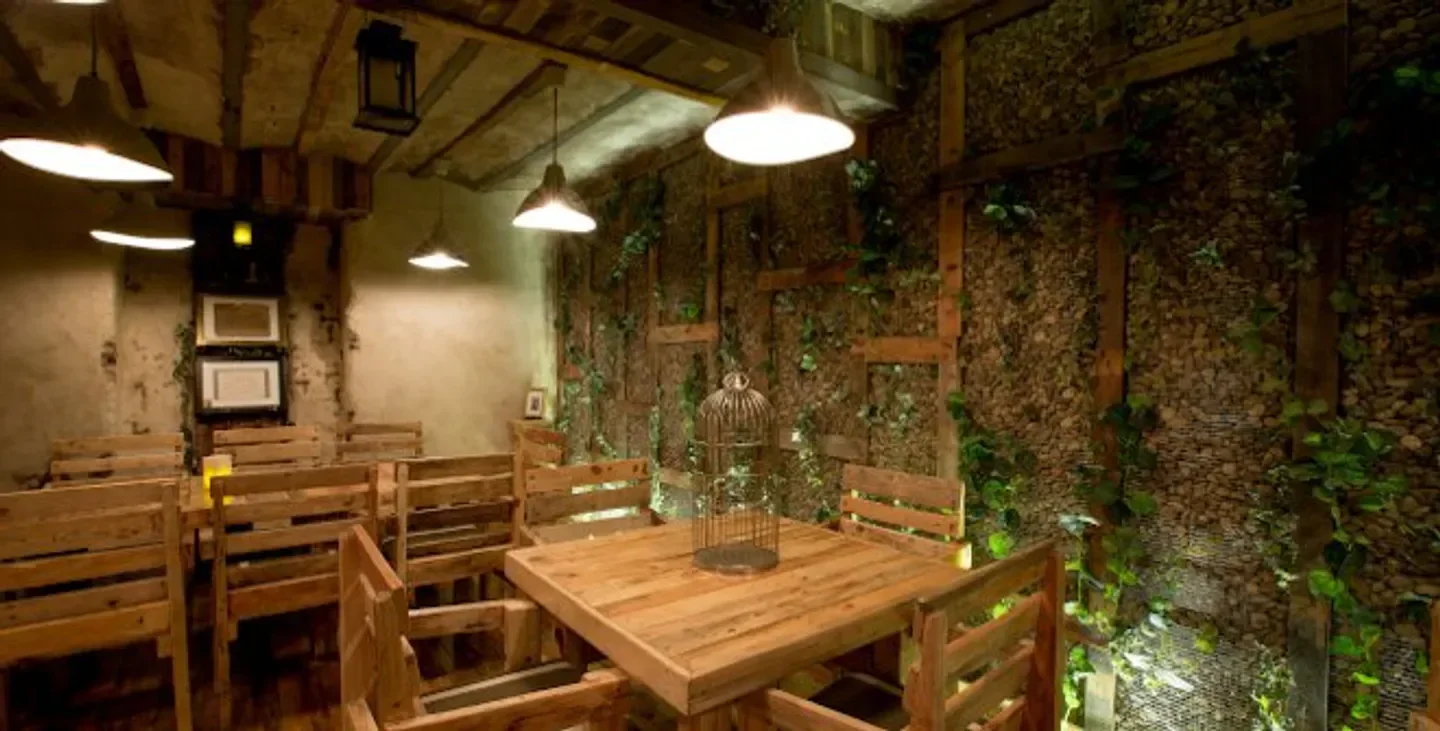 Cozy interior of Yugo The Bunker restaurant in Madrid, with wooden tables and decorative walls.