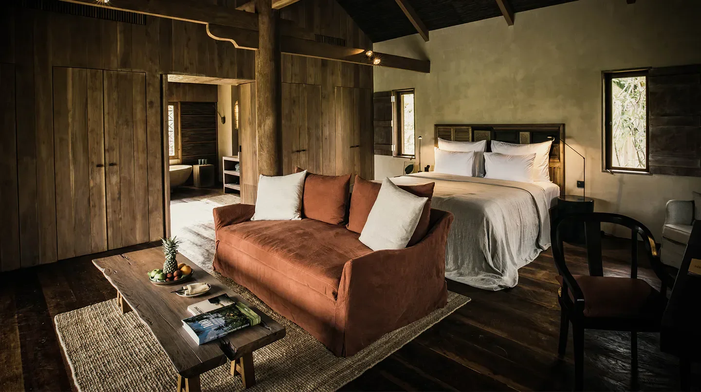 Cozy bedroom interior at Zannier Hotels Phum Baitang in Siem Reap, with wooden accents and natural light.