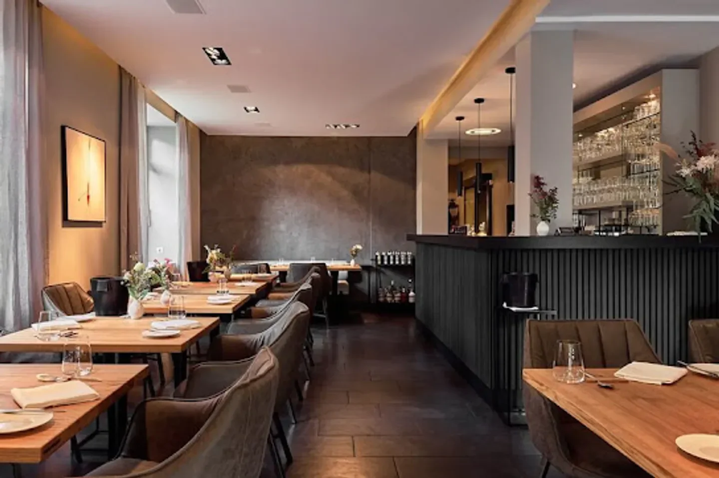 Interior of Zeik restaurant in Hamburg, showing elegant dining tables and bar area.