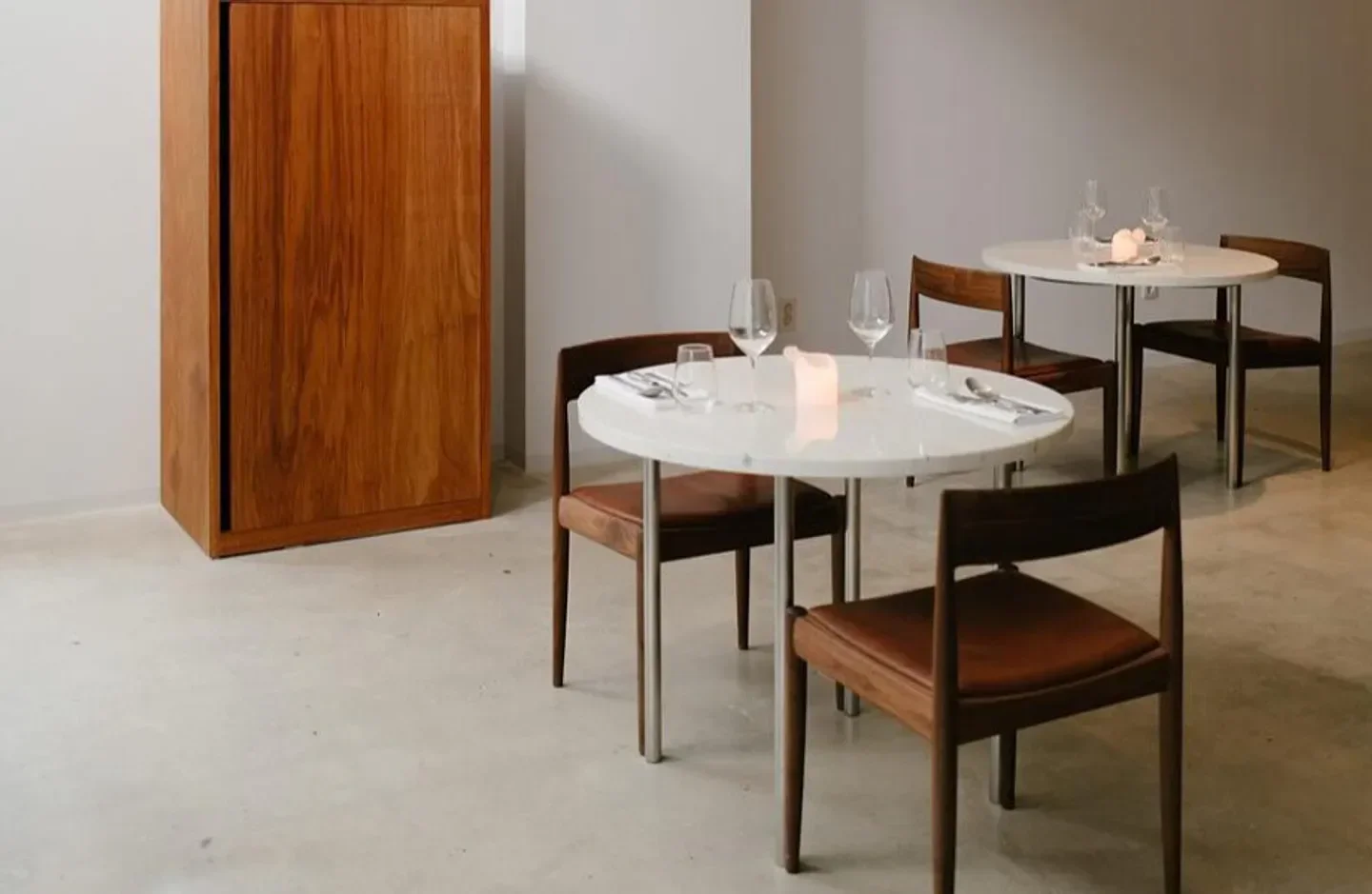 Minimalist interior of Zero Complex restaurant in Seoul, featuring tables and wooden furniture