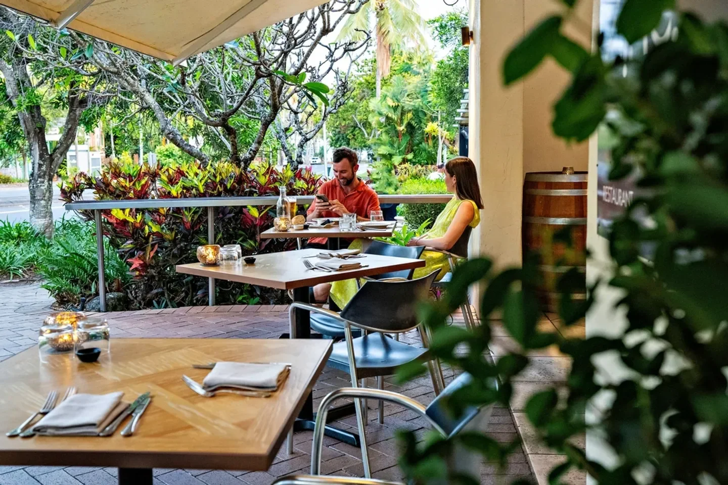 Outdoor dining at Zinc restaurant in Port Douglas, with a couple enjoying a meal.