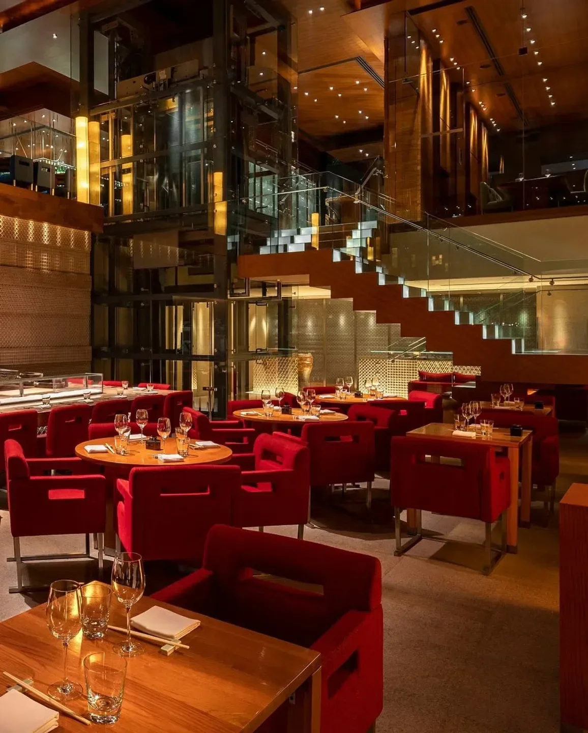 Interior of Zuma Las Vegas restaurant with red seating and grand staircase.